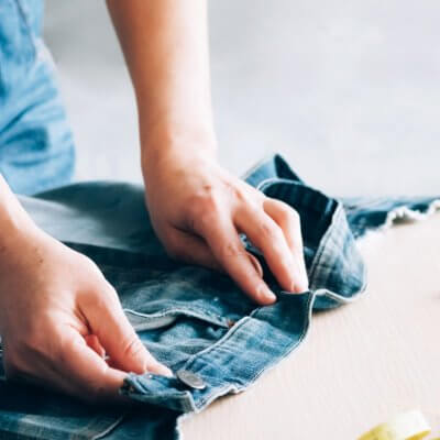 Frau repariert bzw. näht Jeans